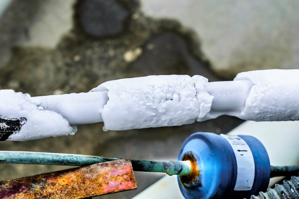 ac cooling air pipes covered by snow or frozen because of super performance of heavy duty central air conditioning system on the roof top in hot summer days