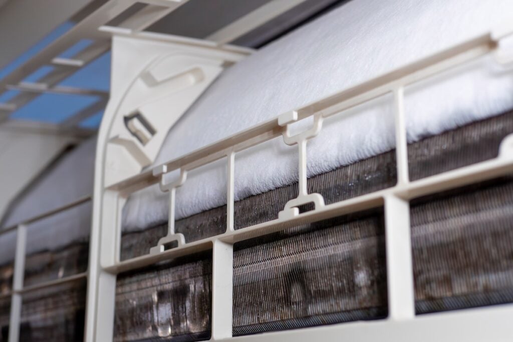 close-up of Frozen or Ice in the air conditioning. Problems with home cooling systems are caused by leaks in heating pipes, hot and cool coils, air pressure, and chemicals.