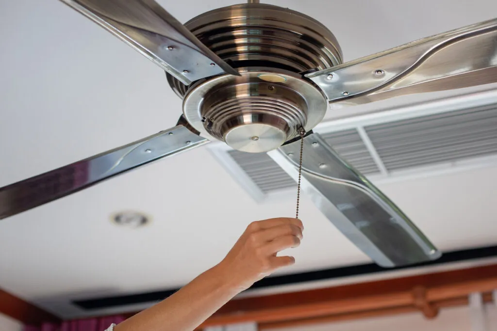 hand pulling string on ceiling fan that stopped working