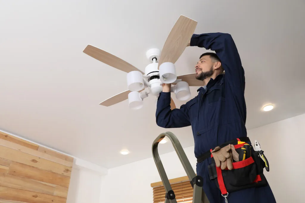 technician fixing ceiling fan that stopped working