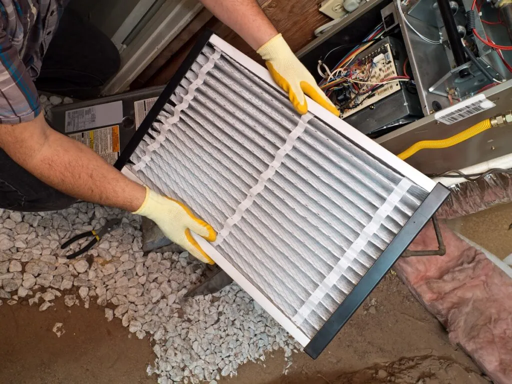 airconditioning repair man performing maintenance. replacing filter