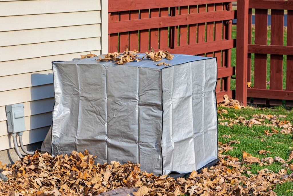 House air conditioning unit with protective cover during fall season