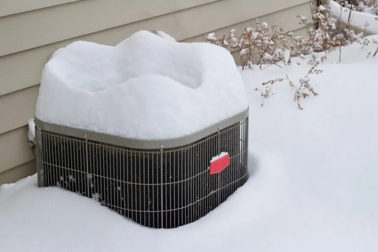 outdoor home air conditioner unit covered with deep snow in winter
