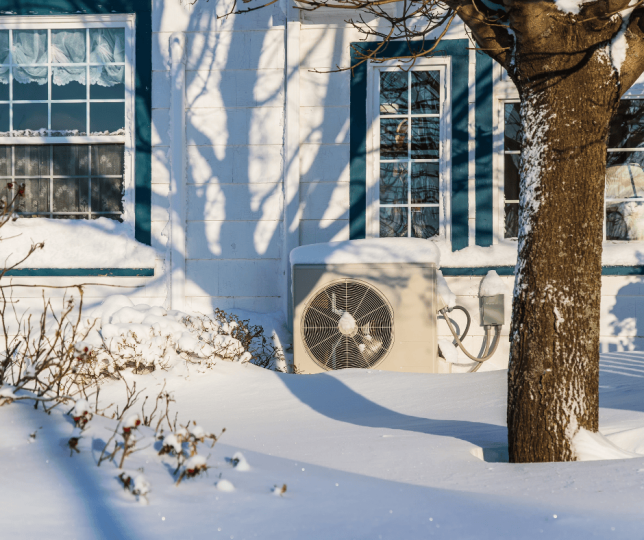 Heat pump surrounded by snow-covered landscape in Minnesota.