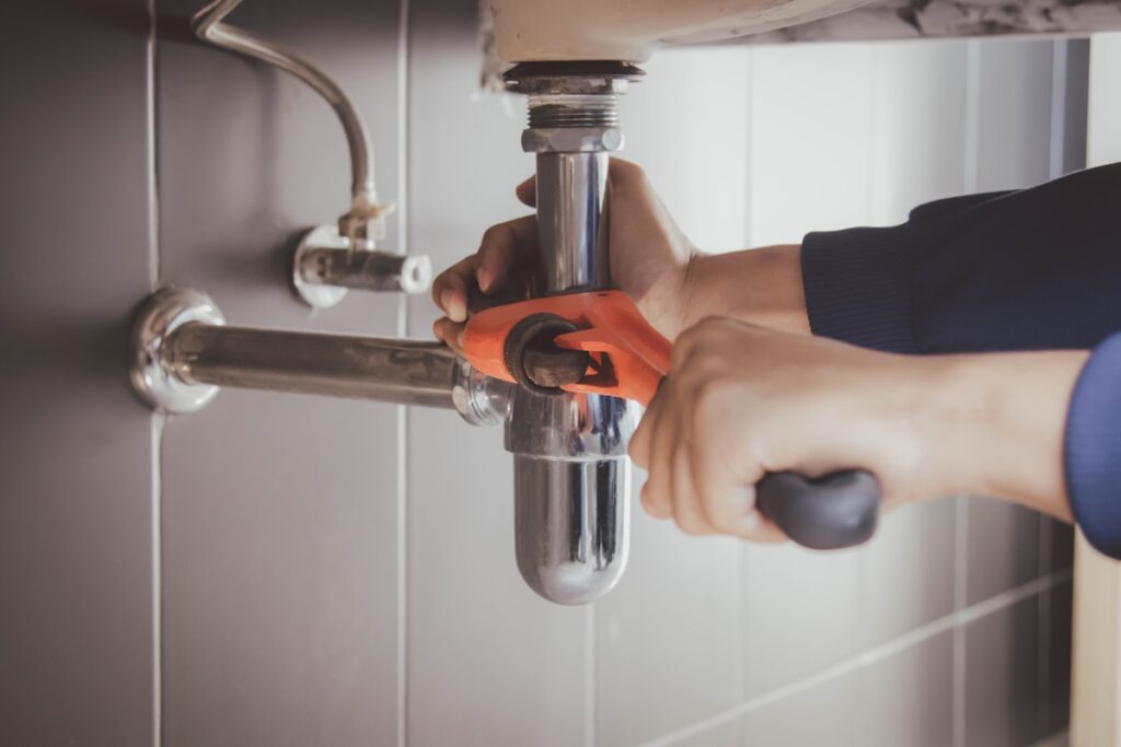 plumber at work in a bathroom, plumbing repair service , fix water plumbing leaks, replace the kitchen sink drain