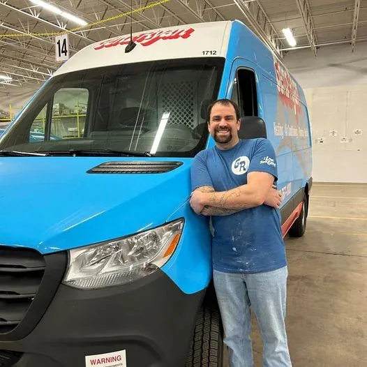 Genz-Ryan plumber standing in front of a work van