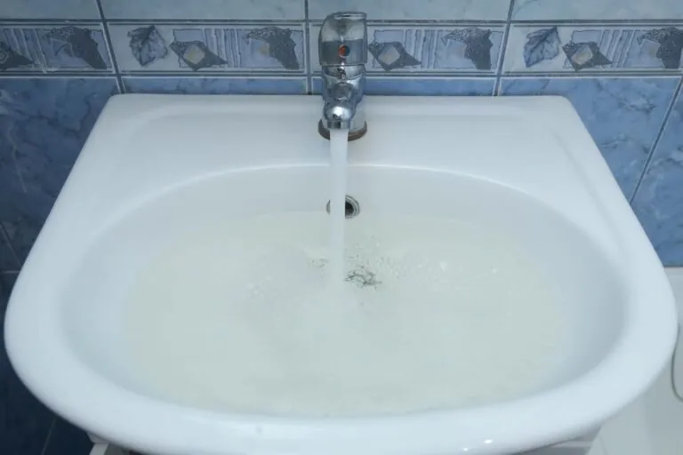 Drain hole in sink is clogged and water is collecting pouring from faucet