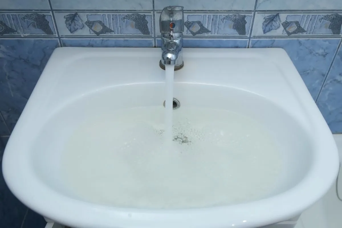 Drain hole in sink is clogged and water is collecting pouring from faucet