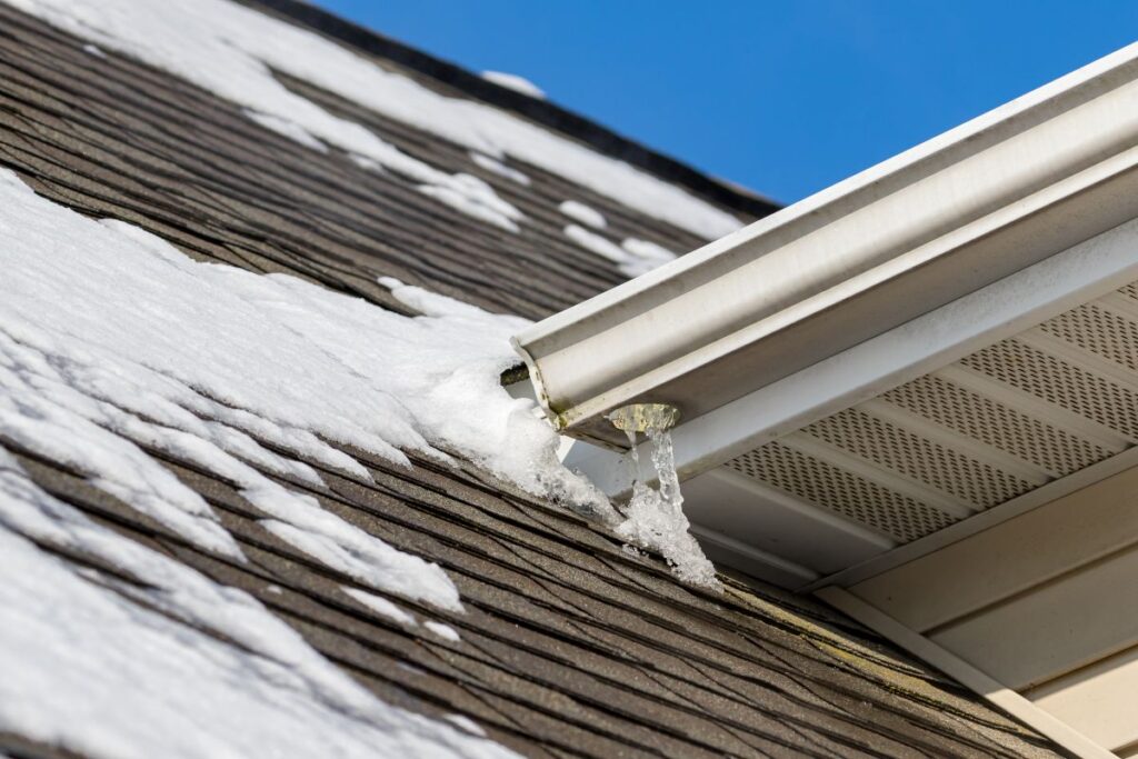 close-up of shingle roof with snow and ice