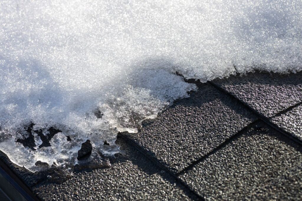 close-up of snow on asphalt shingle roof