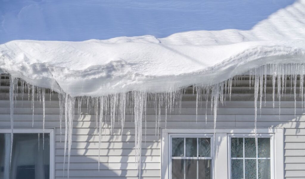 winter house with icicle and snow on the roof