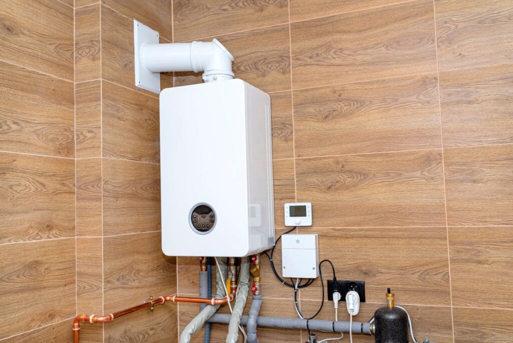 A modern gas boiler for natural gas, installed in a boiler room lined with ceramic tiles.